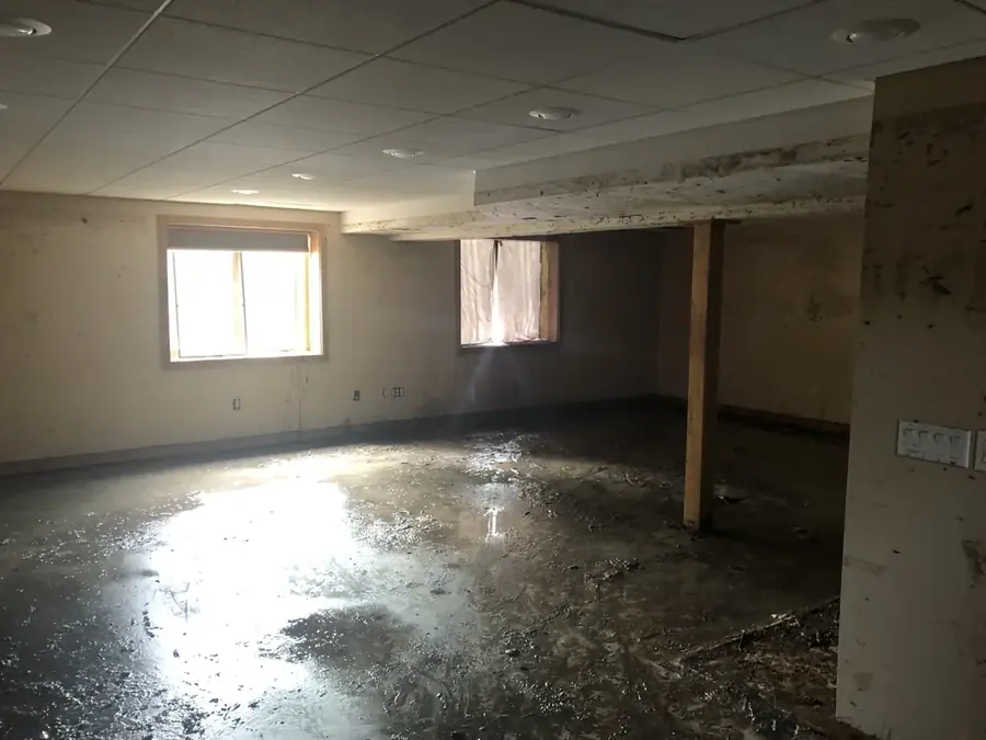 Standing floodwater on a Colorado Springs basement floor after a sump pump failure